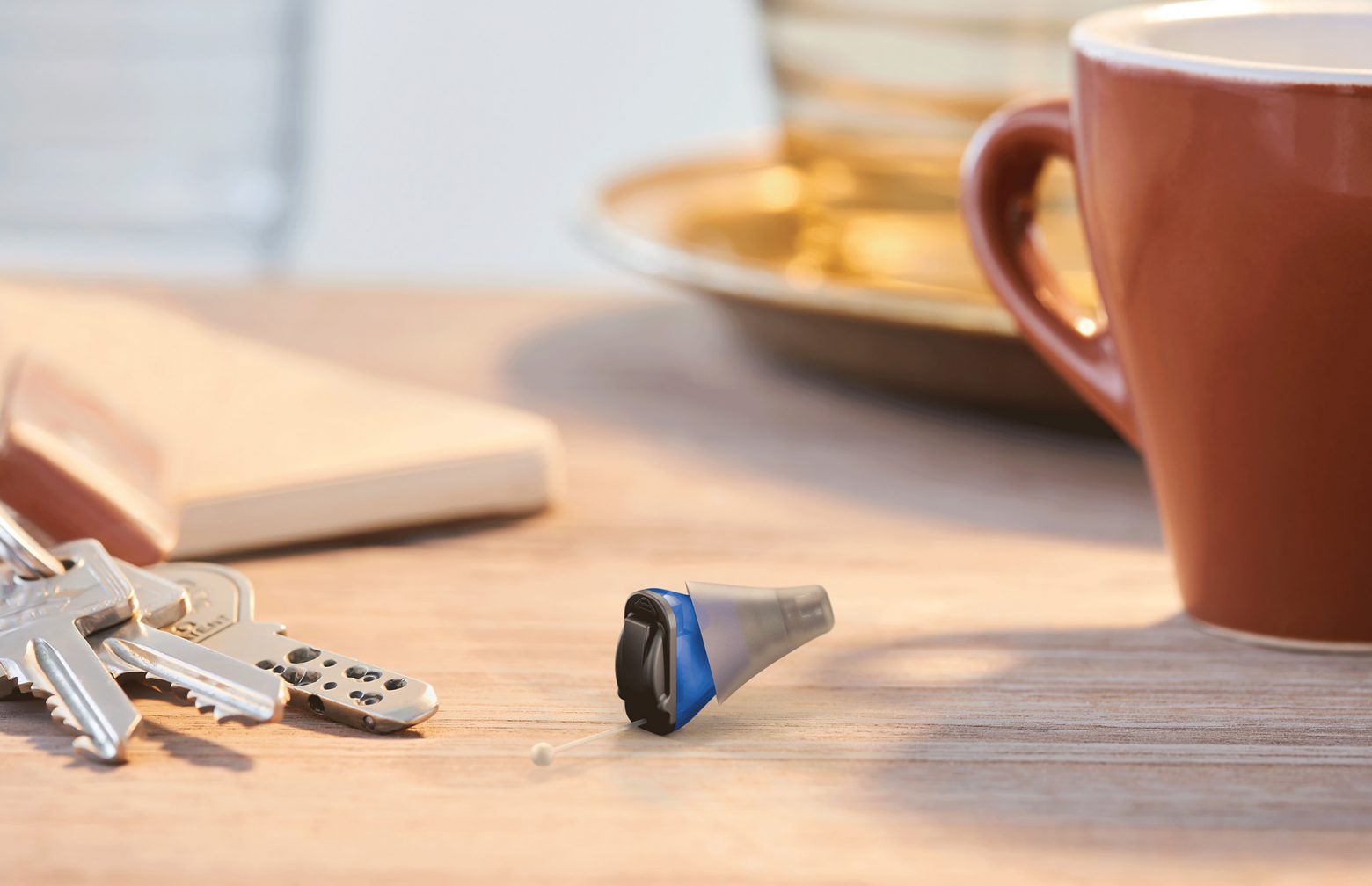 Click CIC laying on a table next to a mug and keys