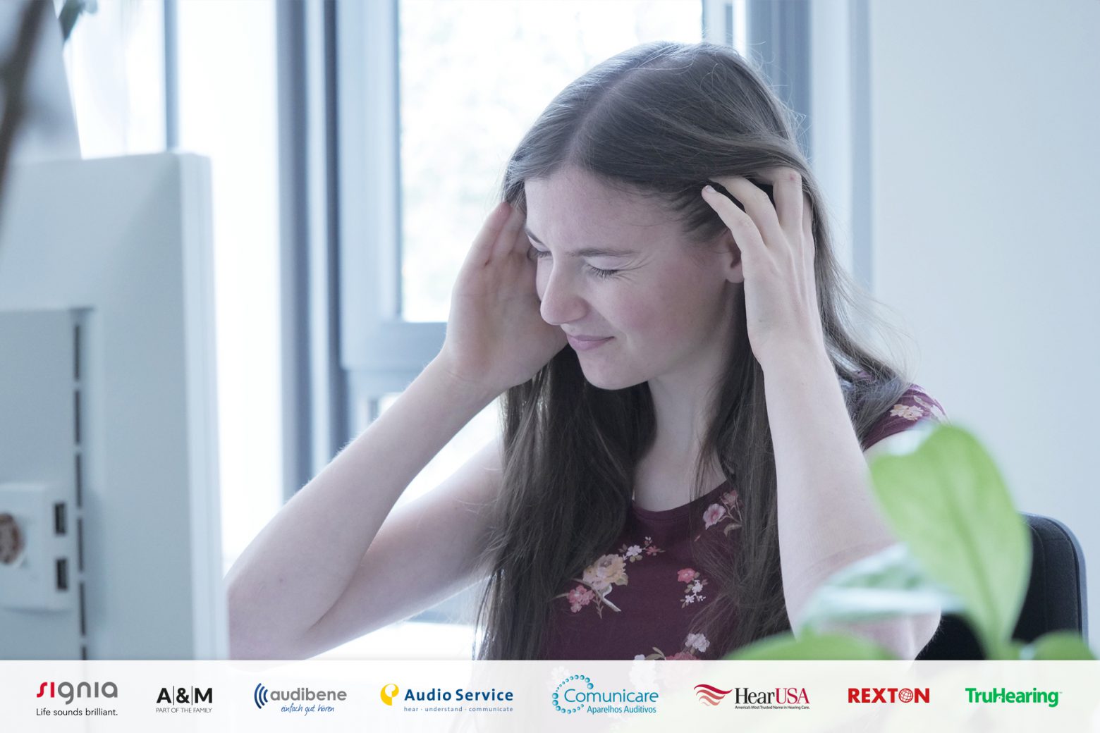 Woman in her office holding her head